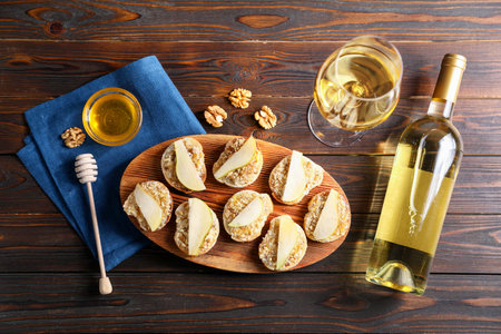 Tasty bruschettas with apples, honey, walnuts on wooden table, flat layの写真素材