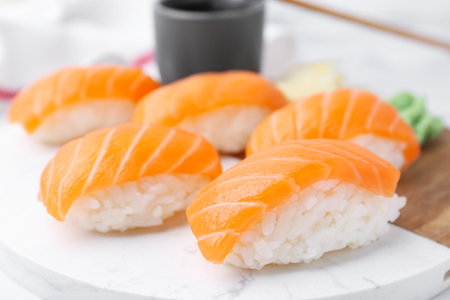 Delicious nigiri sushi with salmon and soy sauce on white table, closeupの写真素材