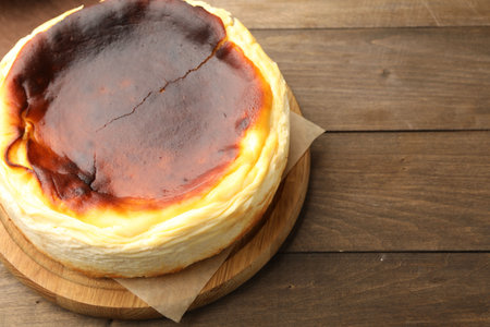 Tasty Basque cheesecake on wooden table, closeup. Space for textの写真素材