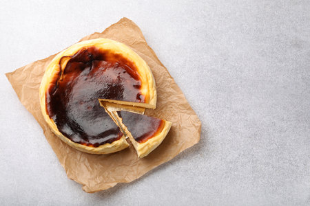 Cut Basque cheesecake on light gray textured table, top view. Space for textの写真素材