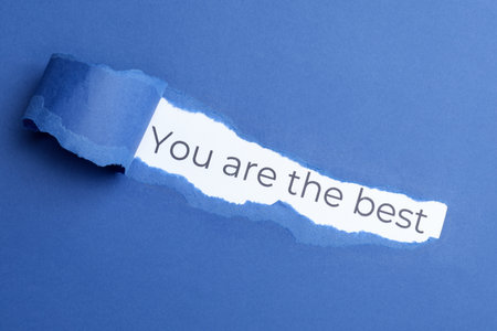 Winner. Phrase You Are The Best on white background, view through hole in torn blue paperの写真素材