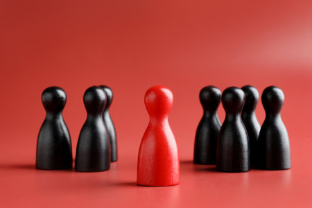 Winner. Human figure in front of black ones on red background, closeupの写真素材