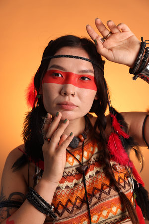 Shaman woman with face painting on orange gradient background