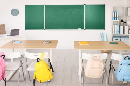 Green chalkboard and stylish furniture in classroom. Mockup for designの写真素材