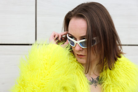 Young woman with piercings, tattoos and stylish clothes outdoorsの写真素材