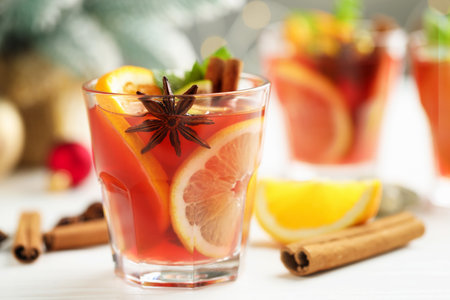Tasty punch drink in glasses, spices and Christmas decor on white table, closeup. Space for textの写真素材