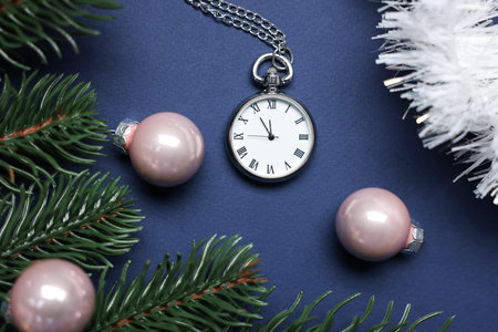 Pocket chain watch, fir tree branches, tinsel and baubles on blue background, flat lay. New Year greeting cardの写真素材