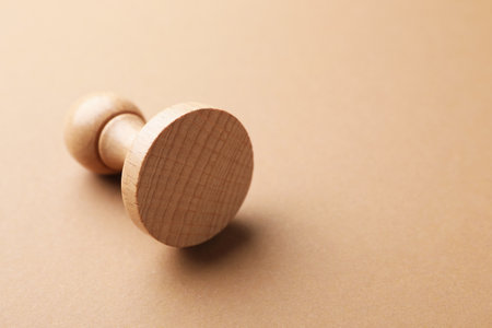 One wooden stamp on brown background, closeup. Space for textの写真素材