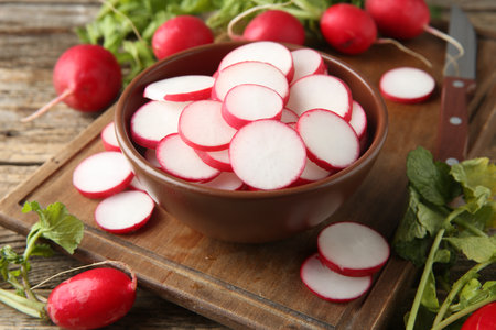 Fresh ripe radishes and knife on wooden table, closeupの写真素材