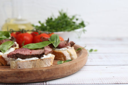 Bruschettas with roast beef served on white wooden table, closeup. Space for textの写真素材