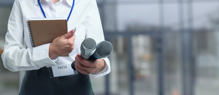 Journalist with microphones and notebooks outdoors, closeup.