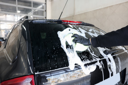 Man washing auto with sponge at car wash, closeupの写真素材