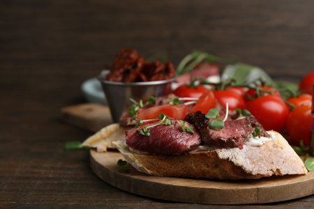Delicious bruschettas with roast beef served on wooden table, closeup. Space for textの写真素材