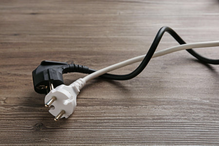 Electrical wires with plugs on wooden table, closeupの写真素材