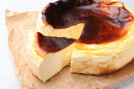 Cut Basque cheesecake on light gray textured table, closeupの写真素材