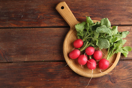 Fresh ripe radishes on wooden table, top view. Space for textの写真素材