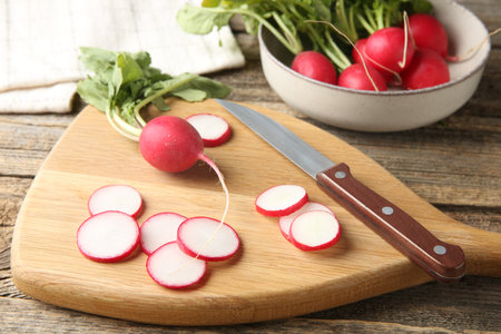 Fresh ripe radishes and knife on wooden table, closeupの写真素材