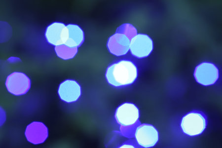 Beautiful blurred Christmas lights on color background, closeup. Bokeh effect