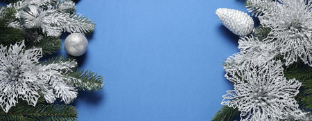 Beautiful composition with fir tree branches and other Christmas decor on blue background, above view. Space for textの写真素材