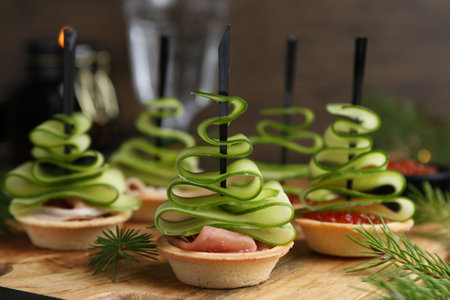 Christmas trees made with cucumber, red caviar, ham and festive decor on table, closeupの写真素材