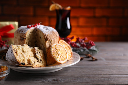Christmas food. Delicious Panettone cake and festive decor on wooden table, closeup. Space for textの写真素材