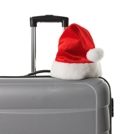 Stylish gray suitcase with Santa hat isolated on white. Christmas vacationの写真素材
