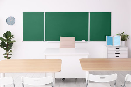Green chalkboard and stylish furniture in classroom. Mockup for designの写真素材