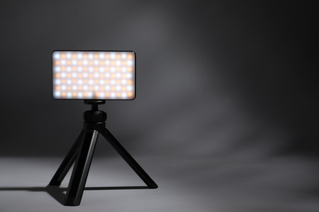 Stylish LED lamp on tripod against gray background, space for textの写真素材