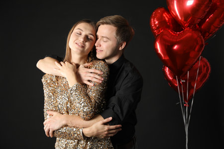 Lovely couple hugging on black background.の写真素材
