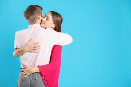 Lovely couple hugging on light blue background, space for text. Romantic dateの写真素材