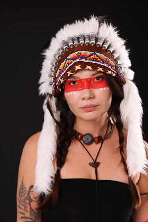 Shaman woman in native American headdress with face painting on black background