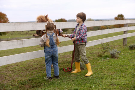 Equine assisted therapy. Cute children with beautiful pony at paddock. Lovely domesticated petの写真素材