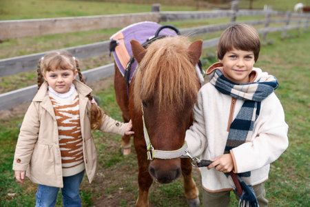 Equine assisted therapy. Children with beautiful pony outdoors. Lovely domesticated petの写真素材