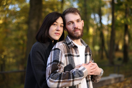Portrait of cute couple hugging in autumn parkの写真素材