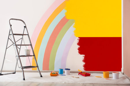 Choosing color for interior. Decorator's tools and paint on floor in room near wall partly painted in different shadesの写真素材