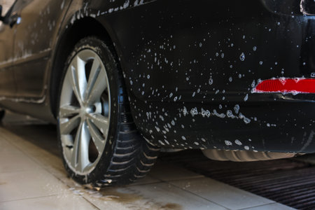 Auto covered with cleaning foam at car wash, closeupの写真素材