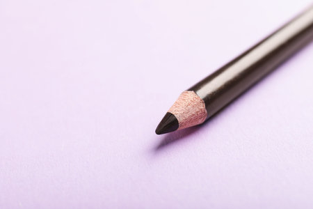 Color eye pencil on pink background, closeup. Space for textの写真素材