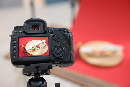 Shooting shrimps with vegetables at table in studio, focus on camera screen. Professional food...