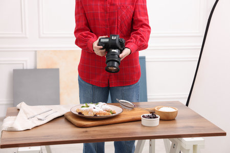 Woman taking picture of food at table in studio, closeup. Professional food photographyの写真素材