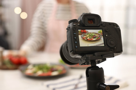 Woman creating composition with caprese salad for shooting in studio, focus on camera. Professional food photographyの写真素材