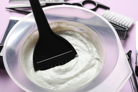 Hair dye and hairdresser's tools on violet background, closeupの写真素材