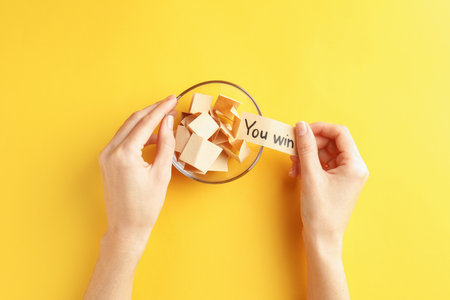 Woman holding note with text You Win and paper pieces on orange background, top viewの写真素材