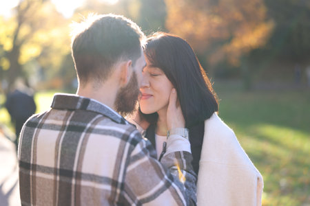 Cute couple kissing in sunny autumn parkの写真素材