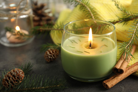 Composition with burning candles and pinecones on black table, space for textの写真素材