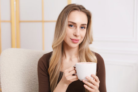 Woman enjoying tasty cocoa drink at homeの写真素材
