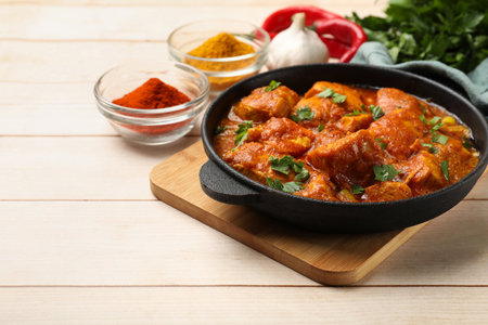 Chicken tikka masala with spices on light wooden table, closeup. Space for textの写真素材