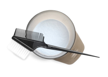 Hair dyeing. Bleach powder in bowl and brush isolated on white, top viewの写真素材