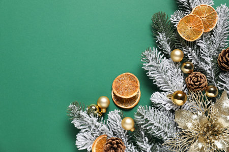 Flat lay composition with fir tree branches and other Christmas decor on green background, space for textの写真素材