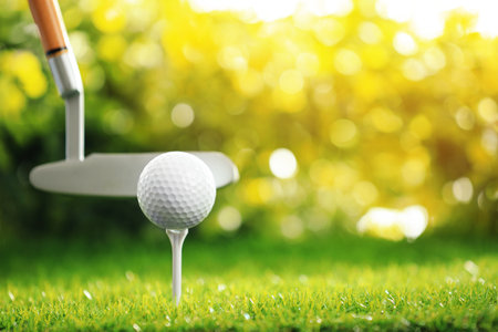 Hitting golf ball with club on green course outdoorsの写真素材