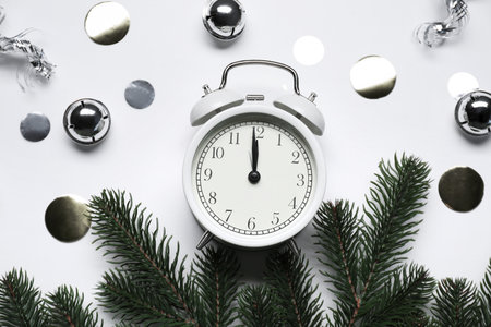 New Year celebration. Alarm clock and festive decor on light gray background, flat layの写真素材